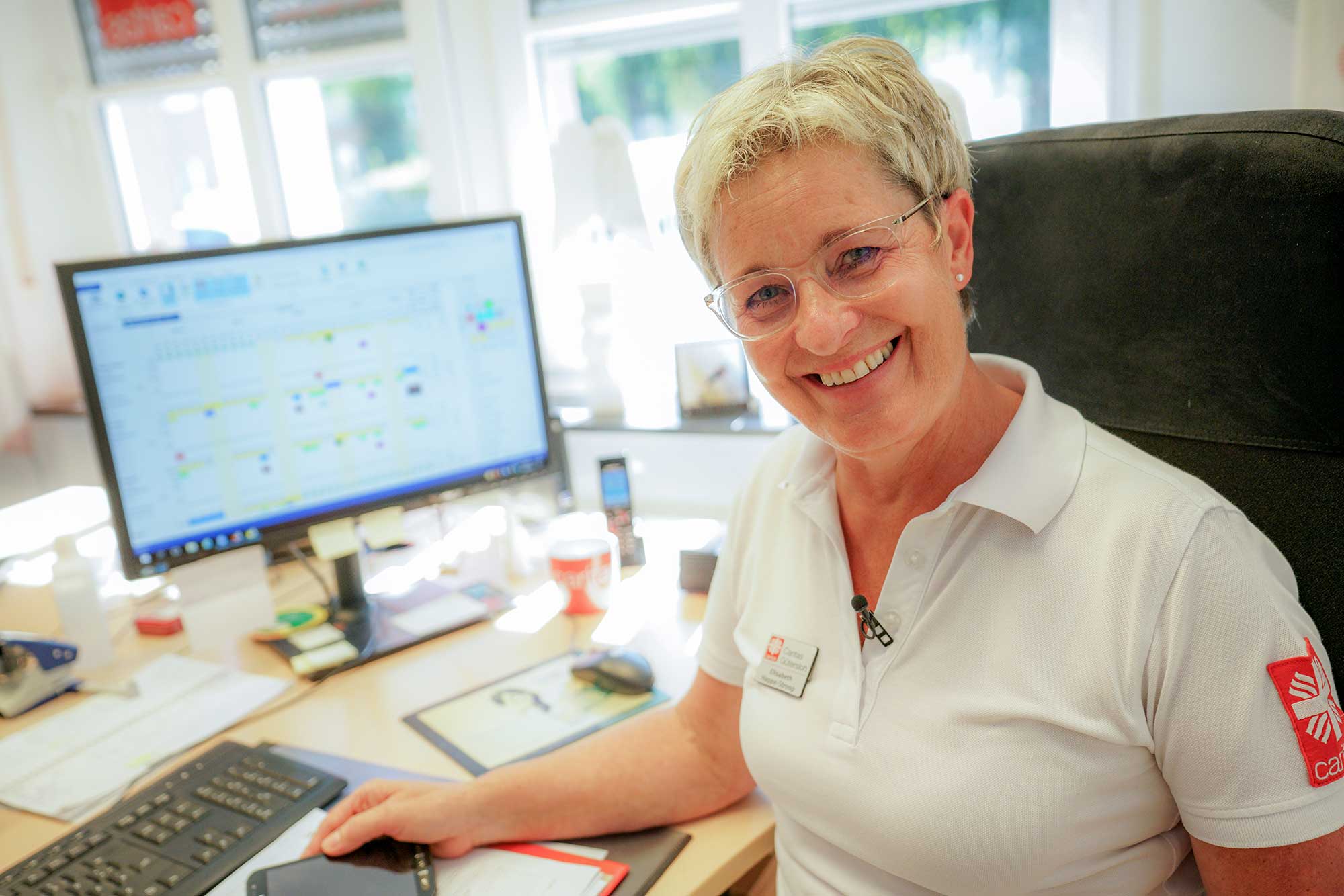 Gemeinsam im Einsatz: Unser Caritas-Haus-Team am Schreibtisch Die fröhlichen Mitarbeiter des Caritas-Hauses in ihrer Büroarbeit, engagiert für eine bessere Gemeinschaft.