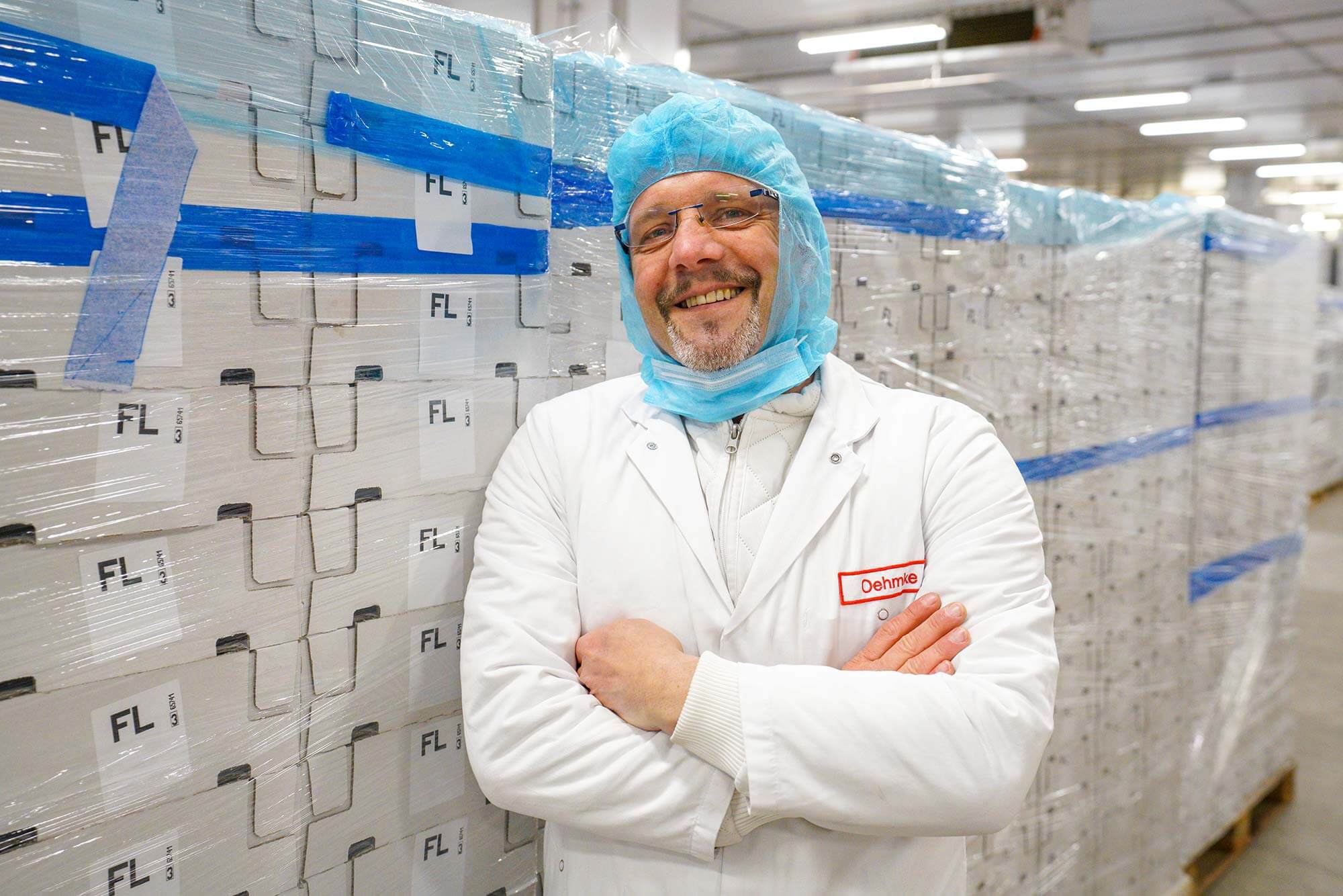 Qualität in jeder Scheibe: Tönnies-Pattys für Ihren Genuss Ein lebensmitteltechnischer Experte von Tönnies präsentiert stolz frisch hergestellte Burger-Pattys vor der Kamera.